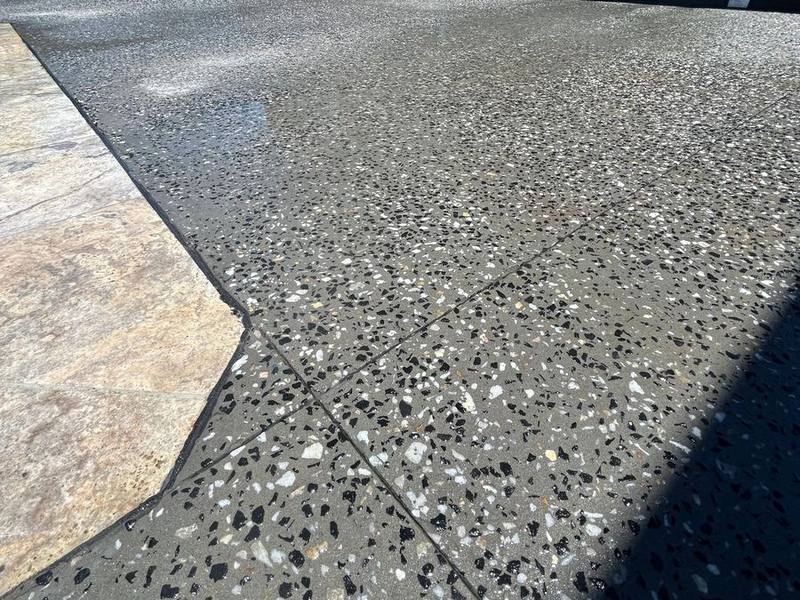 Exposed aggregate concrete finish meeting a stamped surface