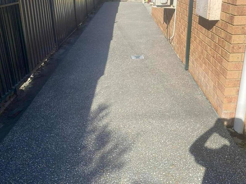 Exposed aggregate side path beside a house